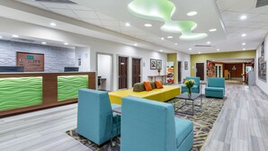 A hotel lobby with a reception desk, seating area, and a hallway leading to other rooms. - Quality Inn & Suites Palatka Riverfront (Palatka)