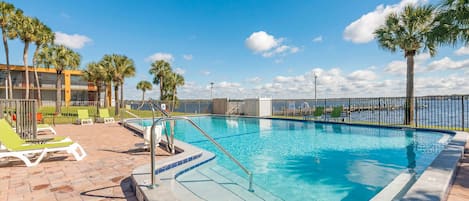 Una piscina al aire libre, sillones reclinables de piscina