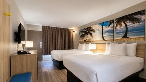A hotel room with two beds, a desk with a phone, a bench, and a painting of a beach scene.