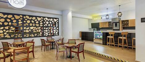 A modern restaurant with wooden furniture and a decorative wall.