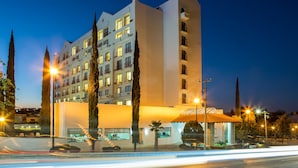 Un hôtel à plusieurs étages au design moderne, doté de balcons et de grandes fenêtres.