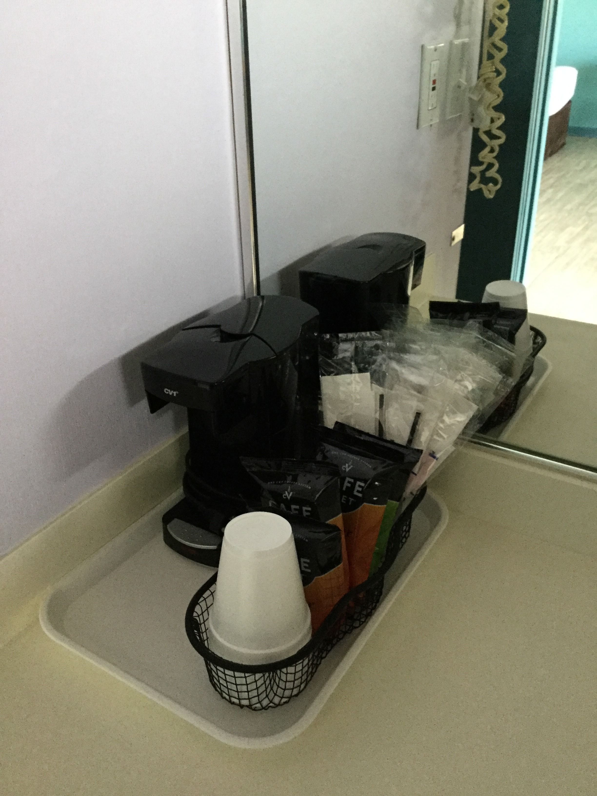 En kaffemaskin med både en bryggare för filterkaffe och en kaffedispenser, placerad på en bänkskiva.