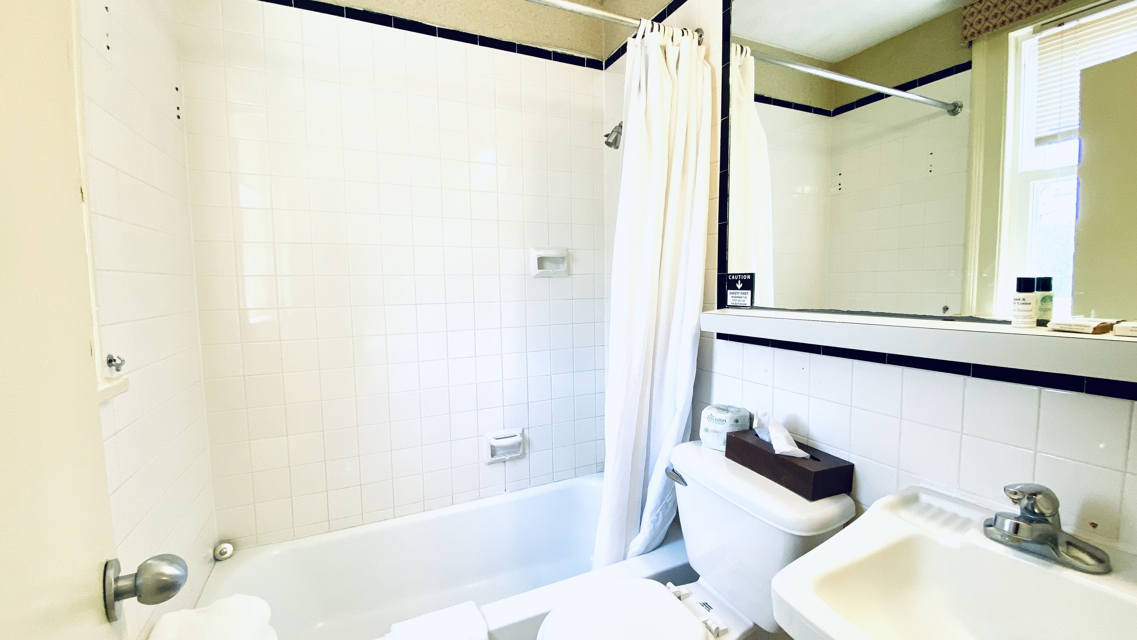 A bathroom with a bathtub, toilet, and sink.