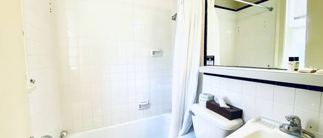 A bathroom with a bathtub, toilet, and sink.