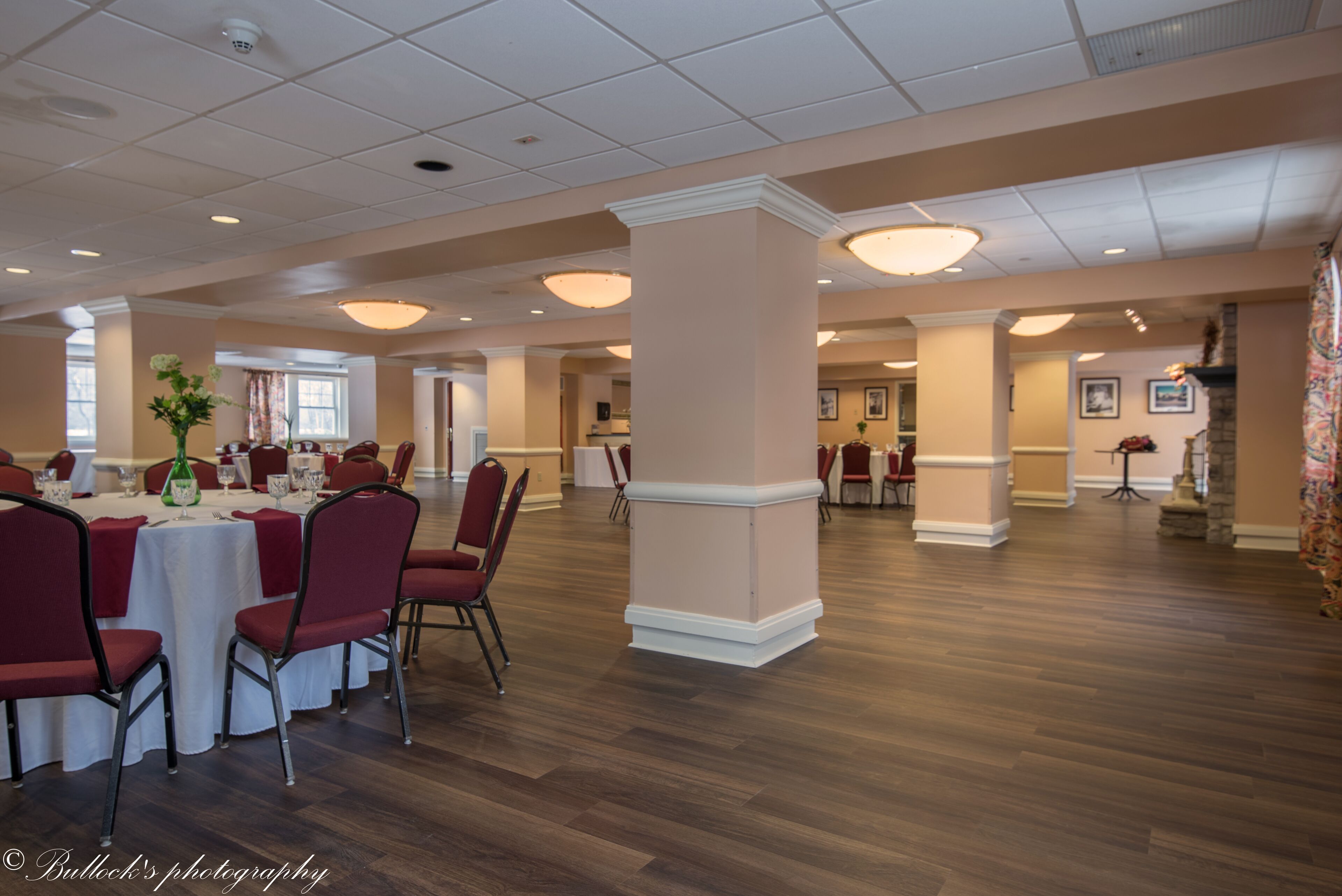 A spacious hotel dining area with multiple tables and chairs, high ceilings, and a modern interior design.