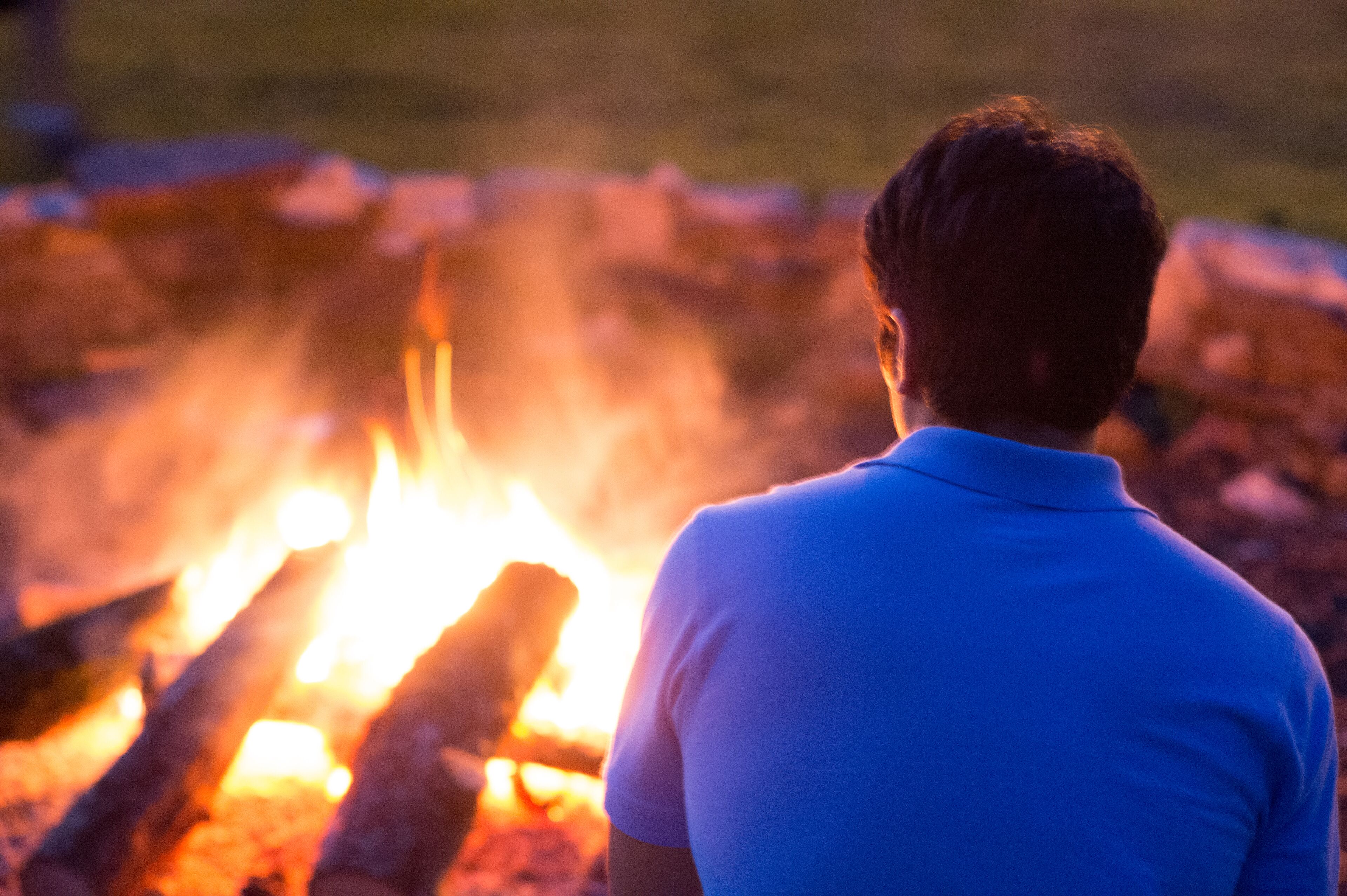 A person standing in front of a campfire.