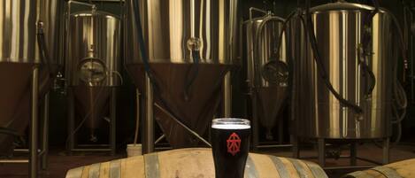 Tanques de elaboración de acero inoxidable y barriles de madera en una cervecería.