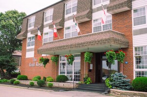 A brick building with a sign reading "The Rodd Royal." It has multiple windows, a covered entrance, and flags.