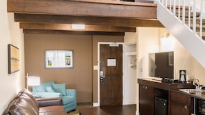 A spacious living area with a loft bedroom, a kitchen, and a dining area. - Rodd Royalty (Charlottetown)
