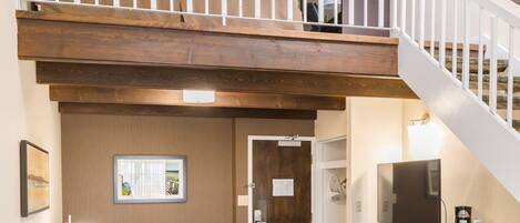 A spacious living area with a loft bedroom, a kitchen, and a dining area.