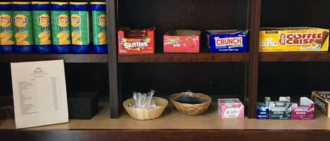 Exhibición de aperitivos y bebidas con una variedad de productos, incluyendo snacks, café y refrescos.