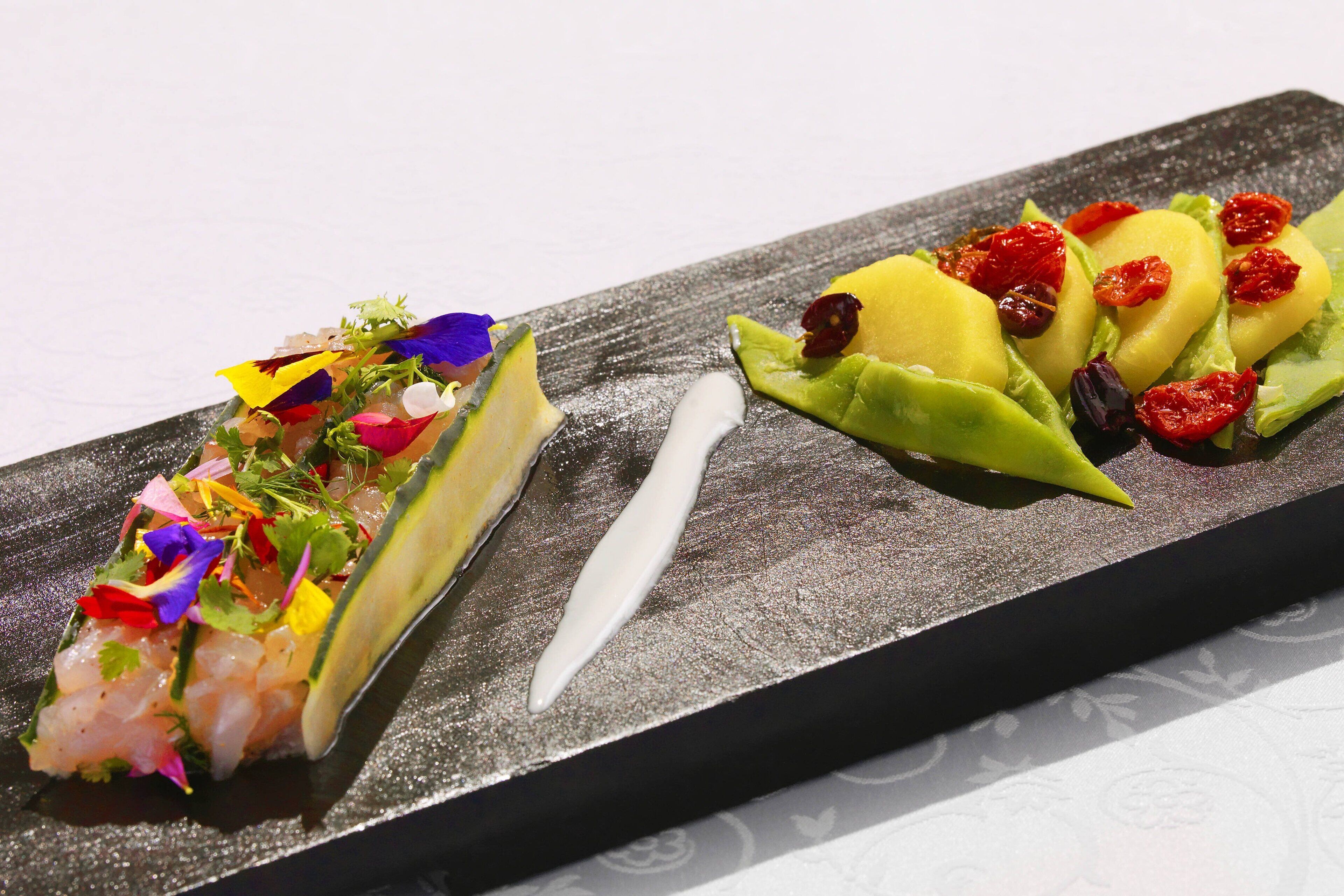 Un plato rectangular con dos presentaciones de comida diferentes.