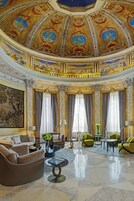 Un lobby lujoso con un techo imponente, muebles elegantes y amplias ventanas.