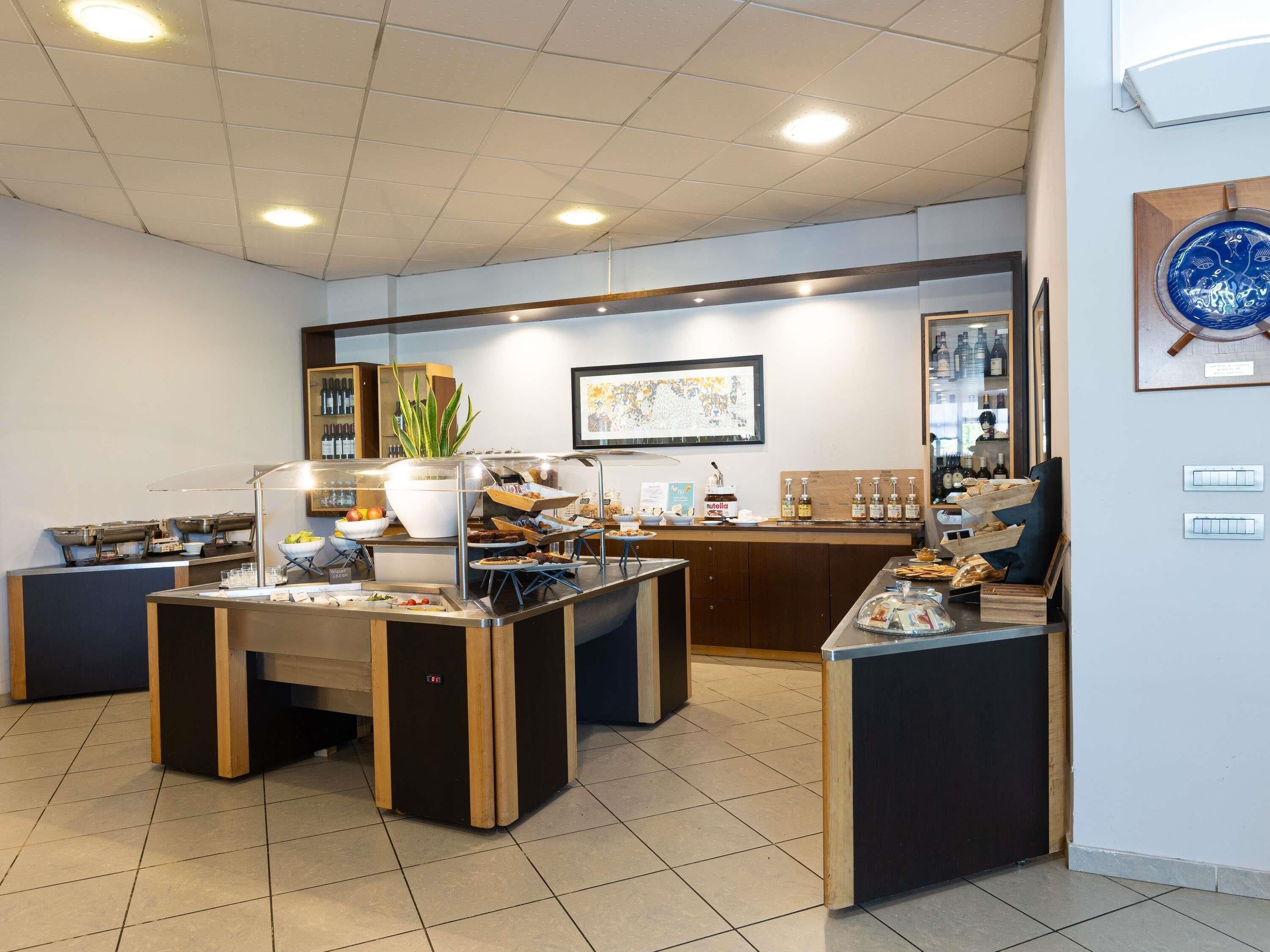 A hotel lobby with a reception desk, buffet area, and a wine display.
