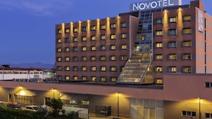 A Novotel hotel with a modern design, featuring a prominent staircase and multiple floors with windows.