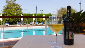 Een buitenzwembad, parasols bij het zwembad en ligstoelen