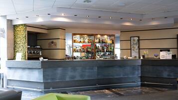 Eine Bar mit einer Theke, Flaschenregalen und einer Kaffeemaschine.