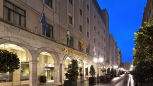 A hotel entrance with arches, a flag, and a sign reading "Meliá Granada". - Melia Granada Hotel (Granada)