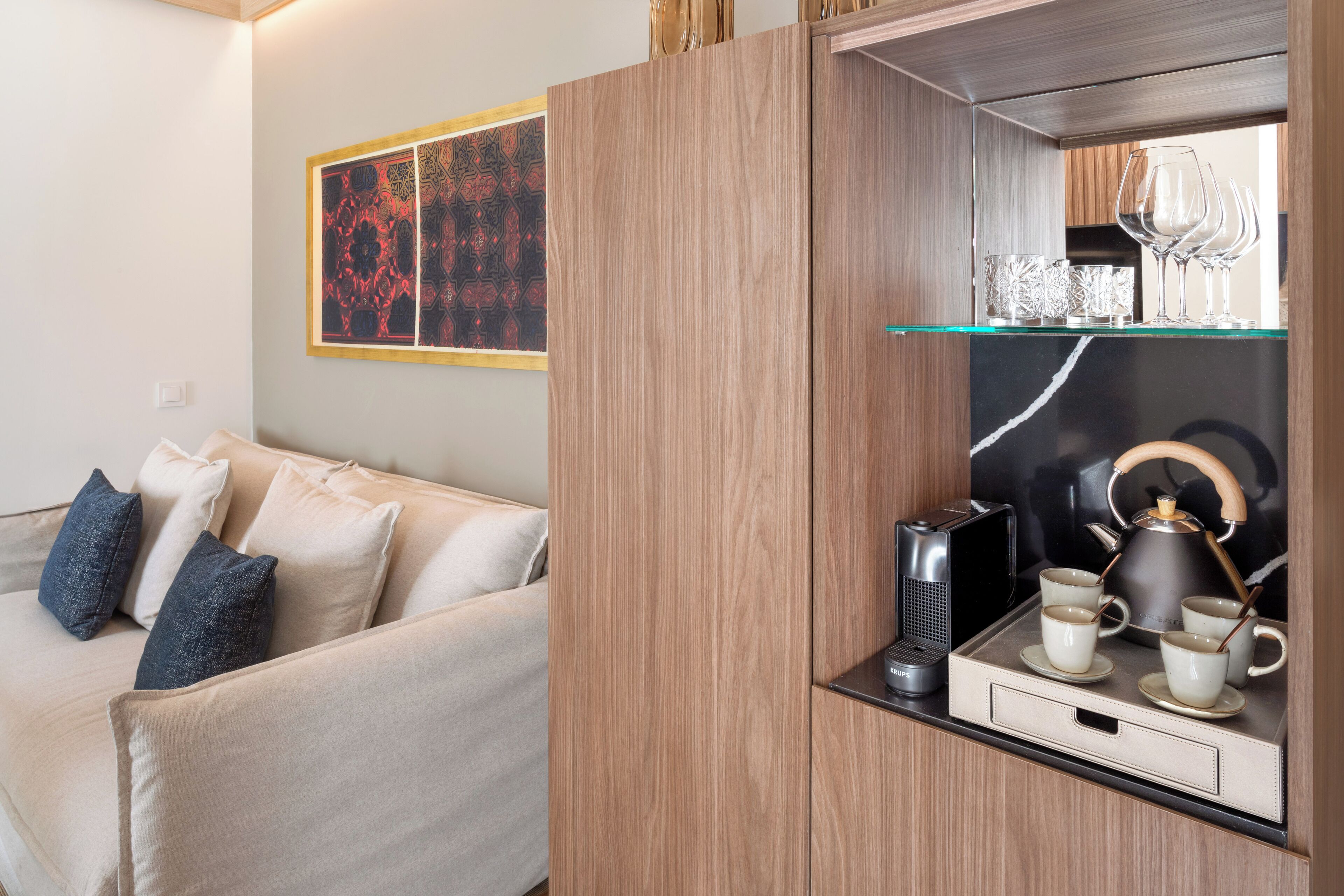 A modern living room with a sofa, a coffee table, and a decorative wall piece.