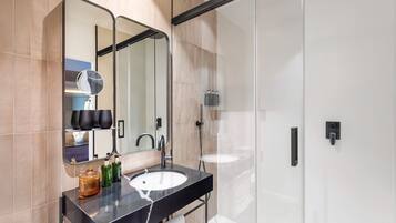 A modern bathroom with a black countertop, a white sink, and a large mirror.