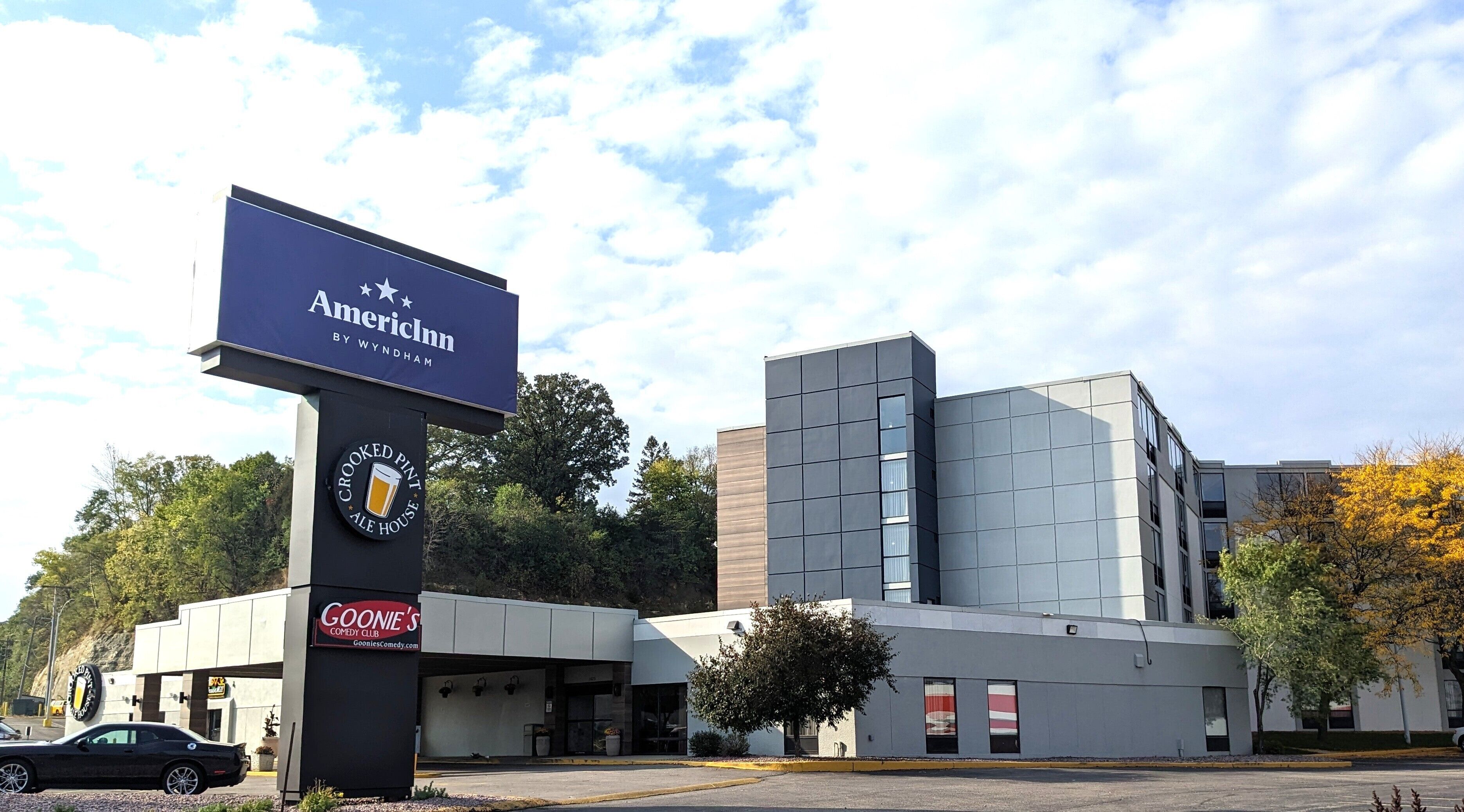 Een modern gebouw met een bord voor AmericInn by Wyndham en Crooked Pint Ale House.