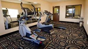A hotel fitness room with treadmills, elliptical machines, and a mirror. - Americas Best Value Inn Roosevelt Ballard (Roosevelt)