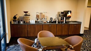 A hotel room with a kitchenette, a dining area with two chairs and a table, and a large window. - Americas Best Value Inn Roosevelt Ballard (Roosevelt)
