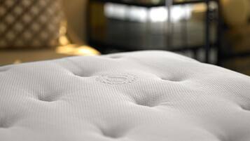 A close-up of a white, textured, tufted headboard with a circular design.