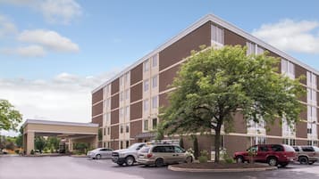 Un hôtel à plusieurs étages, doté d’un parking et d’une entrée abritée.