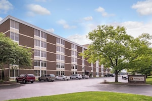 A multi-story hotel building with a parking lot in front.