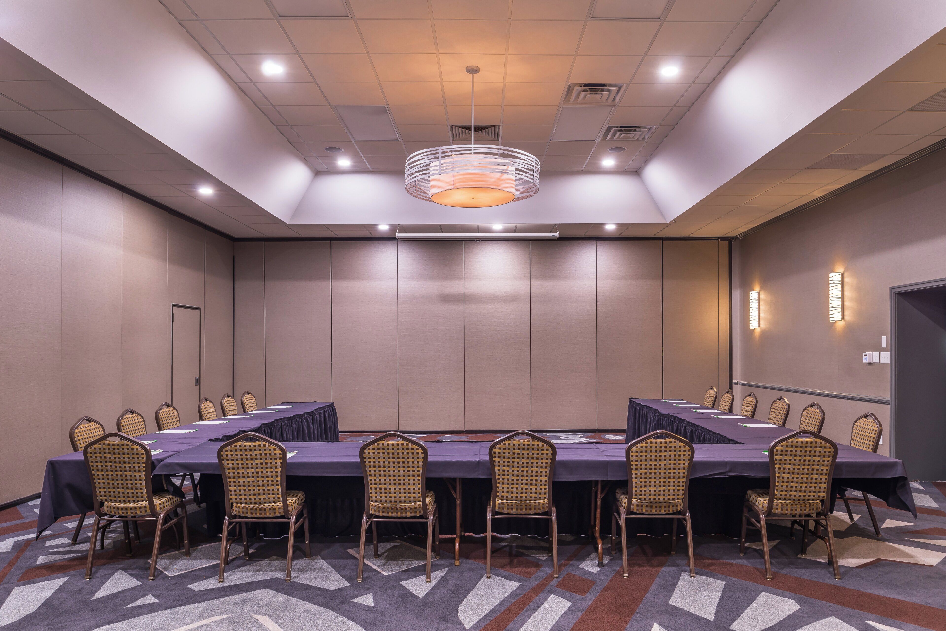 A conference room with a long table, chairs, and a chandelier.