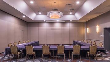 A conference room with a long table, chairs, and a chandelier.