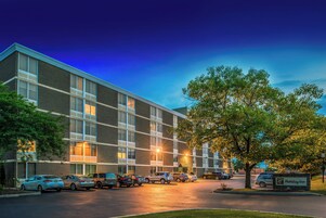 A multi-story building with a parking lot in front, featuring a Holiday Inn sign.