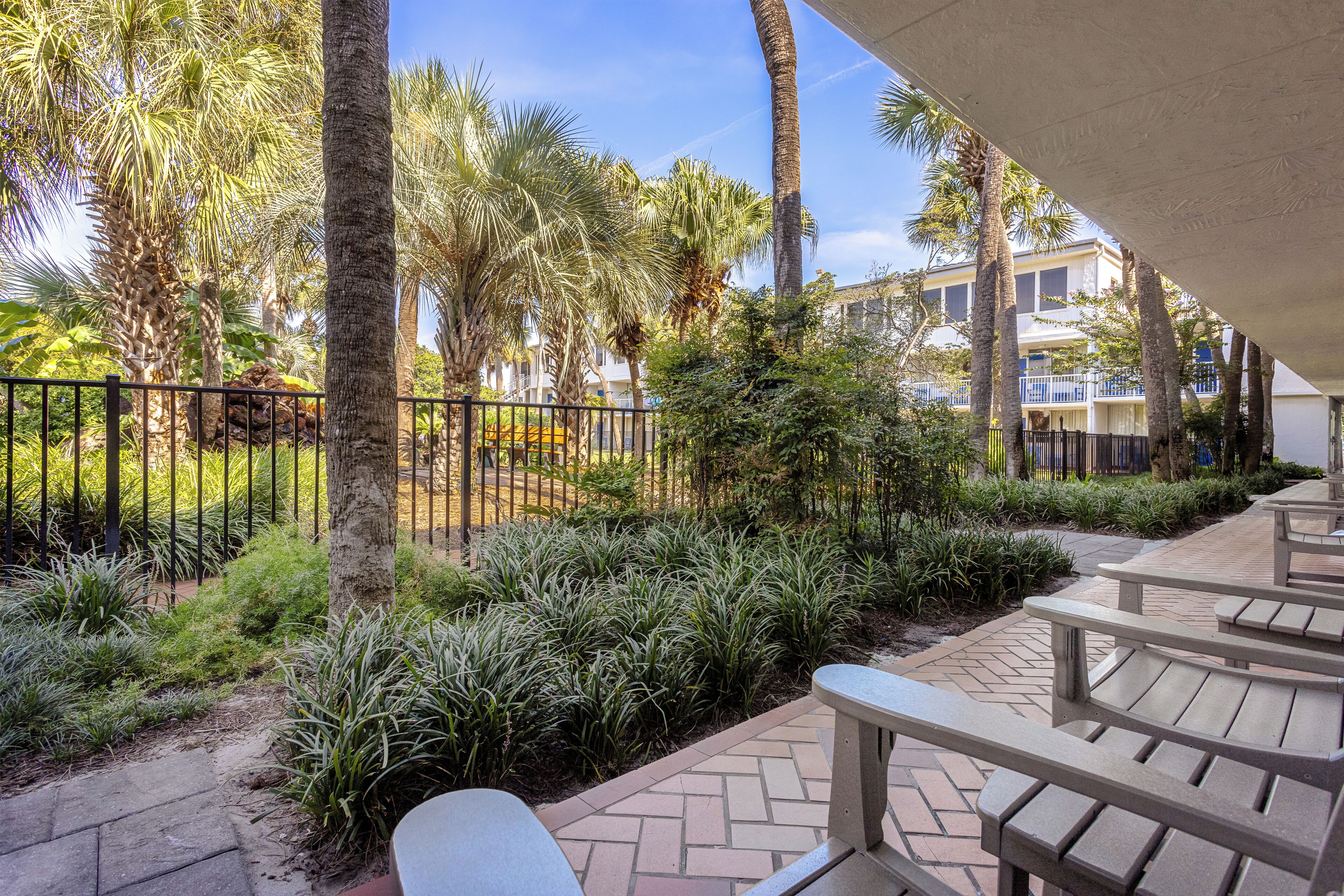 A patio area with outdoor seating and a view of a building with balconies.