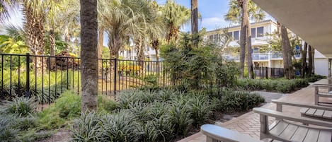 A patio area with outdoor seating and a view of a building with balconies.
