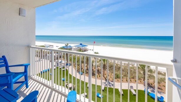 A balcony with a view of the beach, white railing, and blue chairs. - The Island Resort at Fort Walton Beach (Fort Walton Beach)