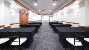 A conference room with a long table, chairs, and a projector screen. - The Island Resort at Fort Walton Beach (Fort Walton Beach)