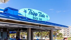 A beach bar named 'Tripp Tide' with a clear blue sky and palm trees in the background. - The Island Resort at Fort Walton Beach (Fort Walton Beach)