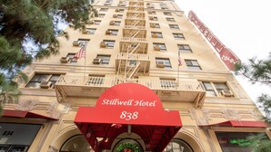 The Stillwell Hotel with a prominent red awning and a fire escape.