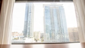 A view through a window of two high-rise buildings with a clear sky.