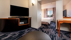 A hotel room with a flat-screen TV, a wooden desk, a bed, and a view of the outdoors. - Fairfield Inn & Suites by Marriott Spearfish (Spearfish)