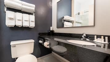 Un baño con inodoro, lavabo y perchero para toallas.
