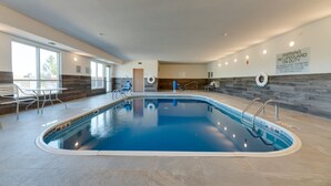 An indoor swimming pool with clear water, a lifeguard sign, and a view of the outdoors through large windows. - Fairfield Inn & Suites by Marriott Spearfish (Spearfish)