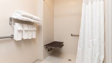 A shower area with a towel rack, a grab bar, and a shower curtain.