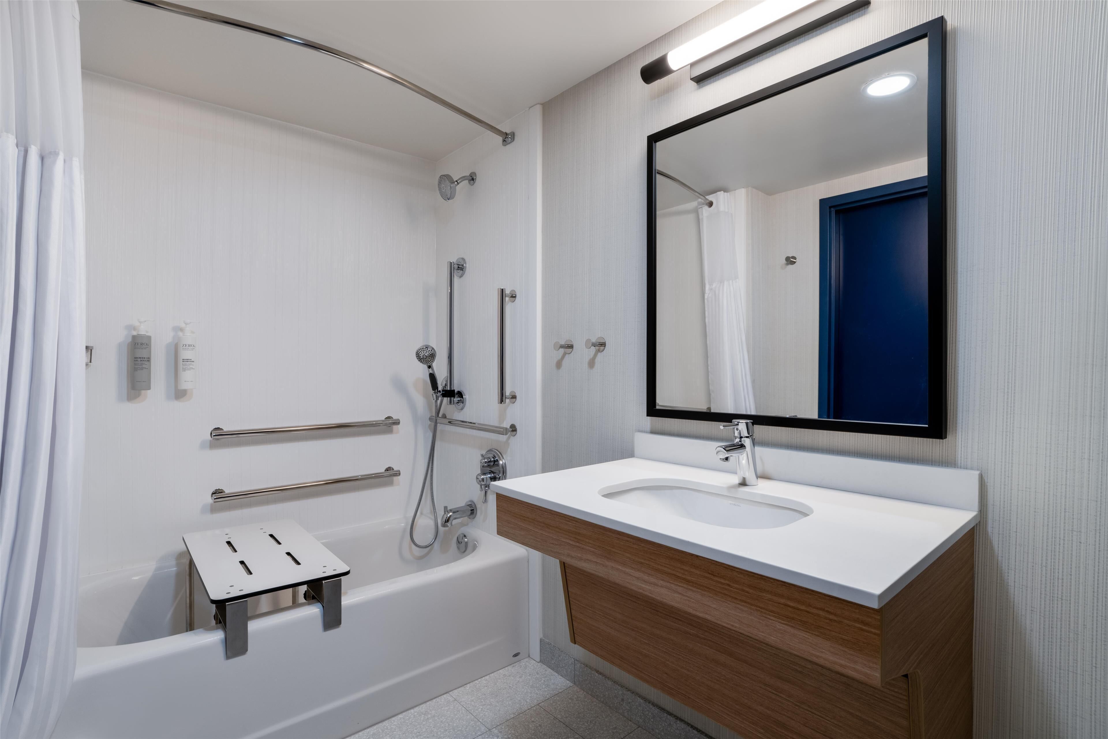 Une salle de bain moderne avec une baignoire, un lavabo et un miroir.