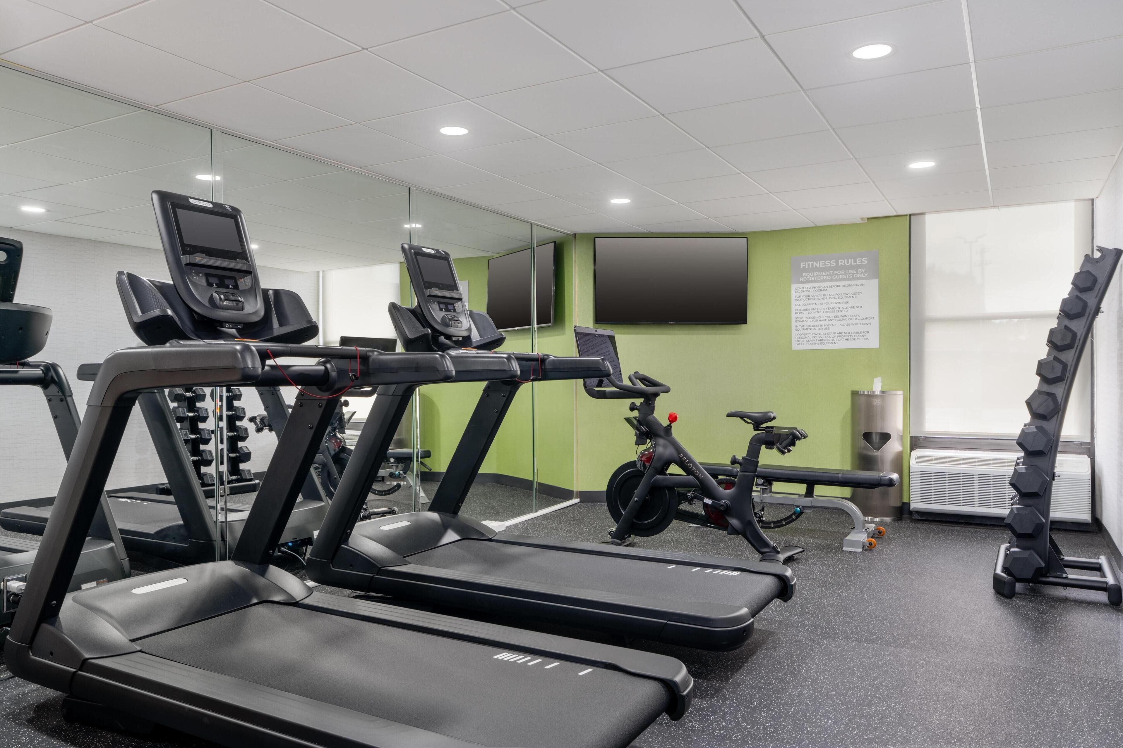 A gym with treadmills, stationary bikes, and weightlifting equipment.