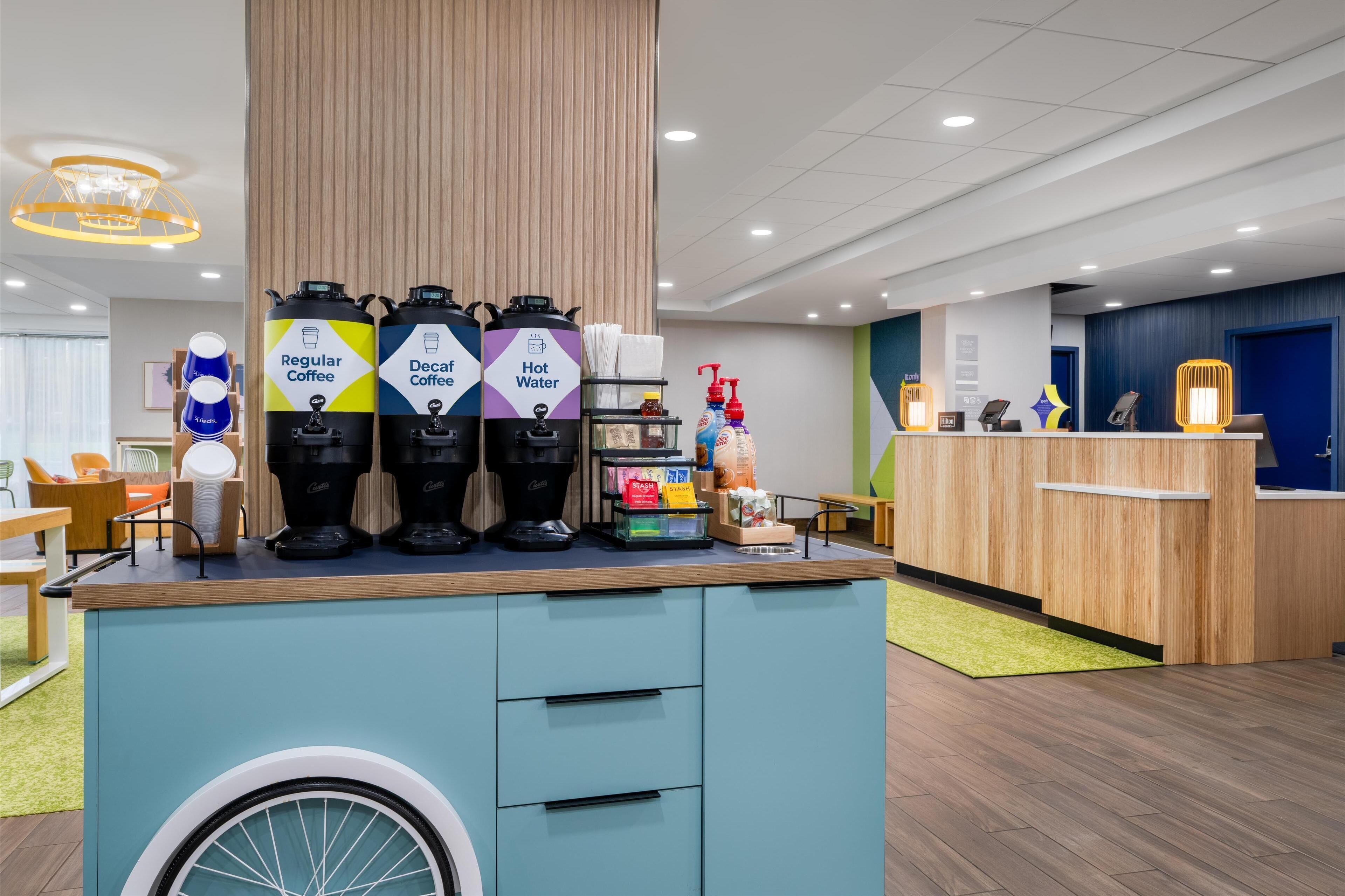 A coffee station with dispensers for regular coffee, decaf coffee, and hot water.