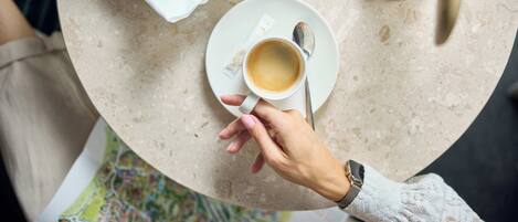 Una mesa con croissants, una taza de café y una cuchara.
