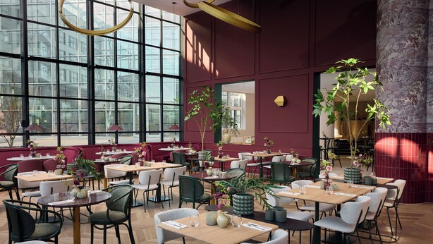 A restaurant with multiple tables and chairs, large windows, and potted plants. - Van der Valk Hotel Paris CDG Airport (Roissy-en-France)