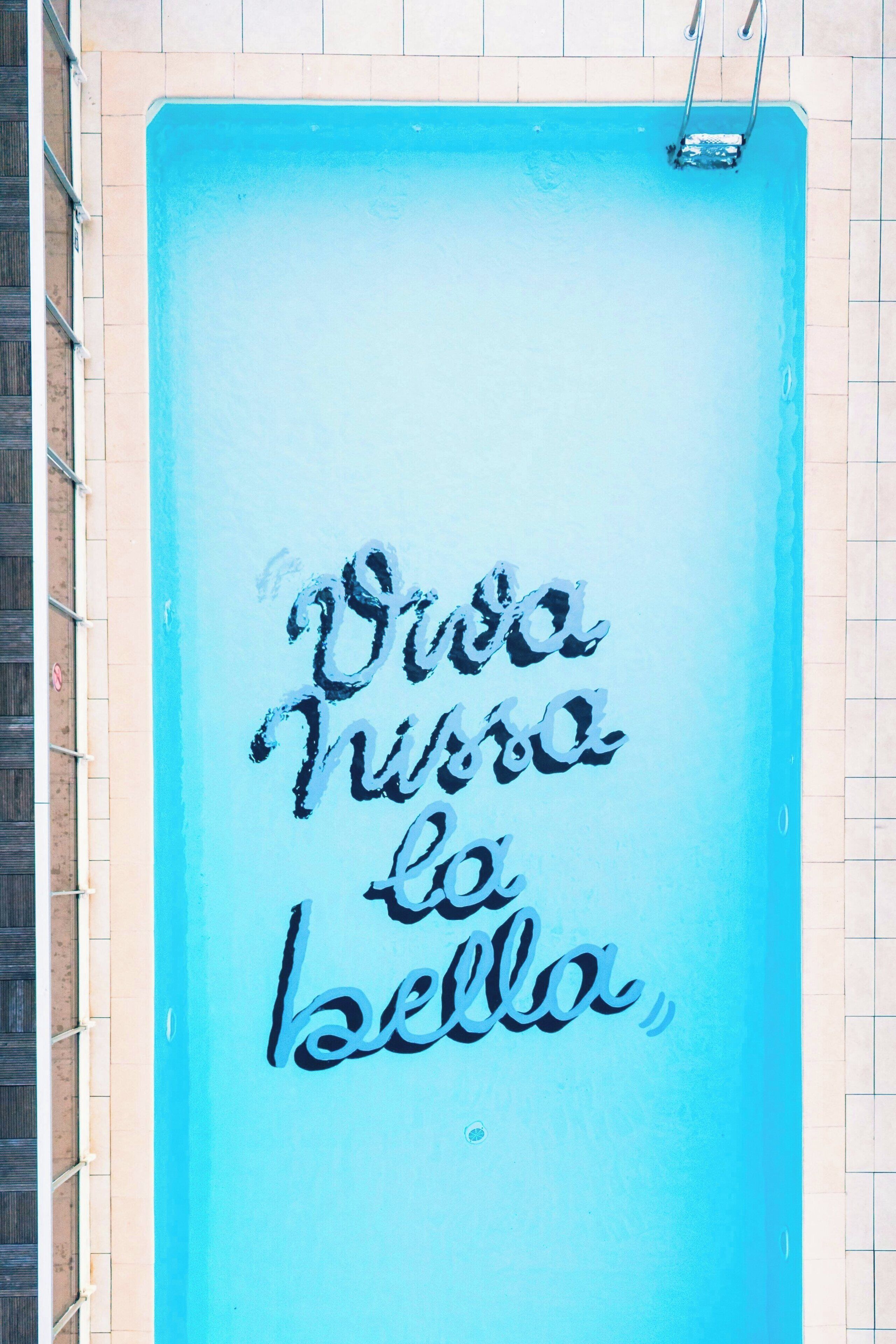 A blue wall with a hand-painted message in cursive.